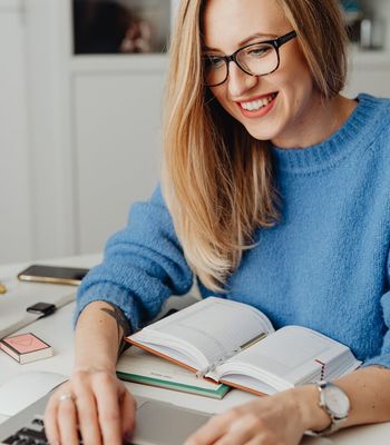 Woman with glasses working on laptop professionally